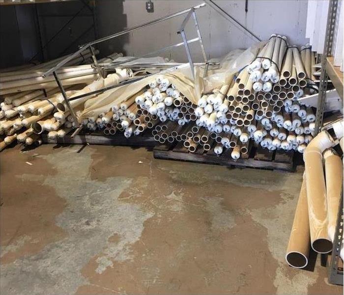 A pile of PVC tubes in a warehouse with flooded water 
