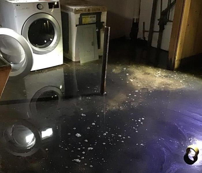 A flooded laundry room with washer and dryer