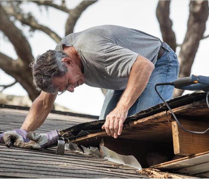 A man inspecting roof