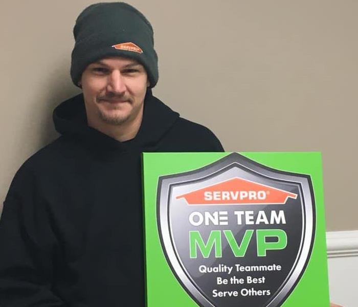Male employee holding the MVP sign